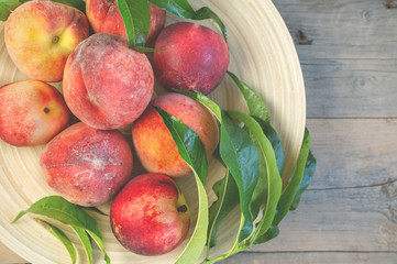 Wall Mural - Fresh juicy peaches with leaves on dark wooden rustic background