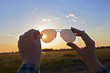 © Larisa - sunglasses in women's hands against the beautiful sky and sunset