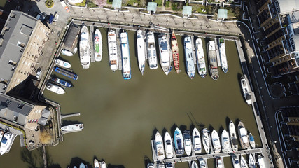 Aerial drone bird's eye view of famous St Katharine Docks Marina and iconic skyline in City of London, United Kingdom