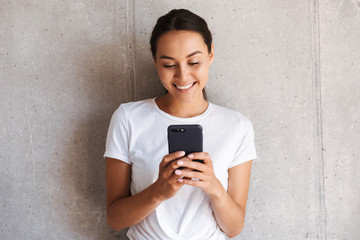 Wall Mural - Smiling young asian woman using mobile phone