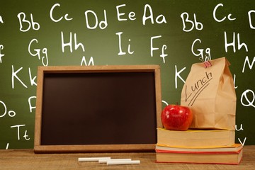 Poster - Composite image of slate with chalks by lunch bag and books on