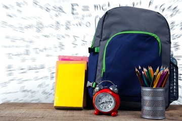 Poster - School supplies by alarm clock on wooden table