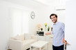 © W PRODUCTION - handsome young man welcome friends at open front door new student home apartment