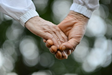 Elderly couple holding hands