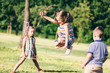 © Photocreo Bednarek - Little girl jumping through the elastic, playing with other children.