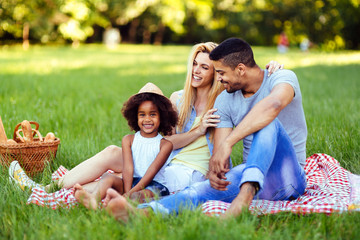 Wall Mural - Picture of lovely couple with their daughter having picnic