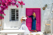 Attraktive, weibliche Touristinnen in Sommerkleidern stehen vor einer typischen Kulisse auf den Kykladen in Griechenland, Naoussa, Paros