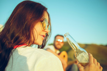 Couple sitting and resting on the beach playing guitar on a summer day near river