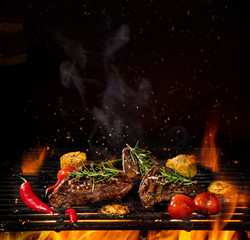 Wall Mural - Beef steaks on the grill with flames