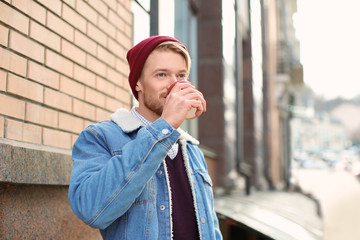 Wall Mural - Portrait of trendy hipster drinking coffee outdoors