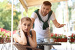 © New Africa - Young couple arguing while sitting in cafe, outdoors. Problems in relationship