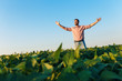 © Zoran Zeremski - Portrait of young farmer standing in soybean field with his arms outstretched.