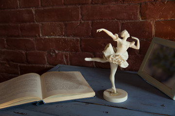 white porcelain figurine of a ballerina with an open book against