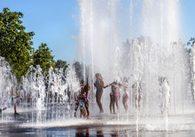 Unidentified Kids Playing In The Fountain In City Park