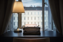 Workplace Of A Writer, Journalist, Creator. An Old Typewriter And A Lamp On The Table. Retro Style. The Concept On Scientific, Historical, Literature, Education And Philosophical Topics.