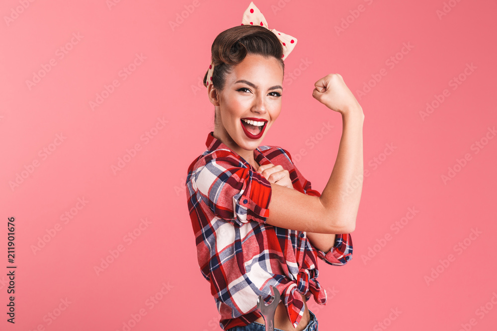 Gorgeous strong young pin-up woman showing biceps. - obrazy, fototapety, plakaty 