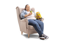 Overweight Woman With A Drink And A Bag Of Chips Sitting In An Armchair