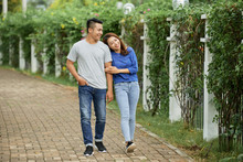 Loving Young Asian Couple Holding Hands And Walking On Pathway In Summer Green Park Being In Love