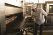 © Wavebreak Media - Male baker using baking owen in bakery shop