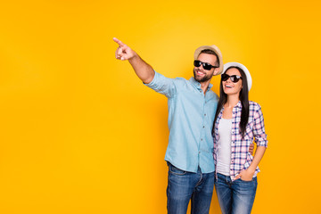 Wall Mural - Portrait with copyspace of stylish trendy traveler in black eyeglasses straw hats gesturing with forefinger enjoying view isolated on vivid yellow background. Advertisement concept