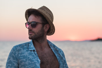 Wall Mural - Young man enjoying sunset by the sea