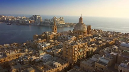 Canvas Print - Valletta, Malta - 4K flying towards Mount Carmel Basilica and St.Paul's Cathedral above the ancient city of Valletta on a summer morning