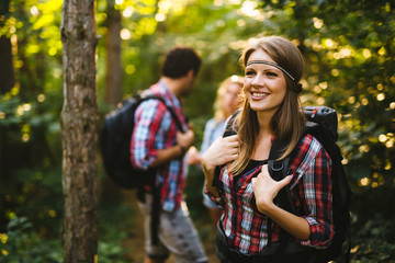 Wall Mural - beautiful woman and friends hiking in forest