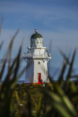 Travel New Zealand. Scenic view of white lighthouse on coast, ocean, outdoor background. Popular tourist attraction, Waipapa Point Lighthouse located at Southland, South Island. Travel concept.