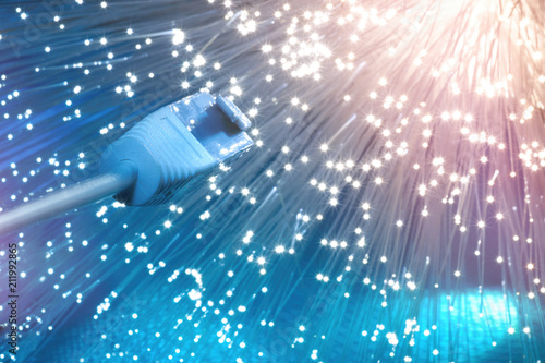 Fotografía Closeup on the end of optical fiber network cable on blue background