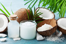 Set Of Natural Coconut Products For Spa Treatment, Cosmetic Or Food Ingredients Decorated Palm Leaves. Coconut Oil, Water And Shavings.