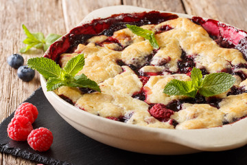 Summer berry cobbler of raspberries and blueberries close up in a dish baking dish. horizontal