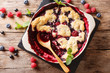 English cuisine: berry cobbler is decorated with mint closeup.  horizontal top view