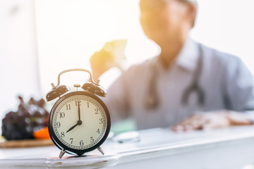 Clock on doctor clinic table for times to healthcare checkup time appointment concept.