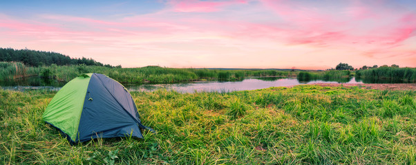 Wall Mural - green tourist tent on the river bank at dawn