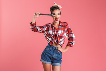 Poster - Amazing young pin-up woman holding wrench.