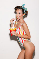 Canvas Print - Pretty pin up woman eating french fries looking camera.