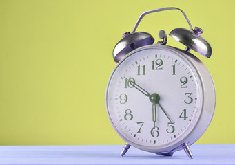 Wall Mural - Retro alarm clock on a pastel background, copy space.