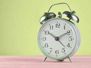 Wall Mural - Retro alarm clock on a pastel background, copy space.