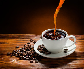 Coffee cup and coffee beans on  wooden background