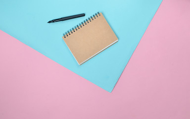 Poster - Notepad and pen on a colored pastel background. Minimalism, top view.