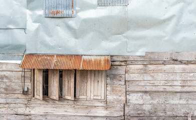 Wooden window and rusty roof with old wooden wall