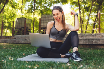 Sticker - Portrait of a smiling young fitness girl using laptop