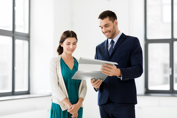 Poster - real estate business, sale and people concept - happy smiling realtor with folder showing documents to female customer at new office room