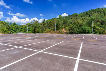 Wall Mural - Empty parking lot with forest and beautiful blue sky.