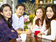 © imtmphoto - happy young asian adults looking at camera smiling in coffee shop