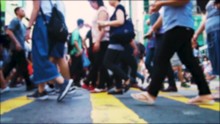 Anonymous pedestrians crossing intersection on busy road in central of big asian metropolis. Crowded crosswalk. Slow moving unrecognisable people at rush hour. Tracking shot.
