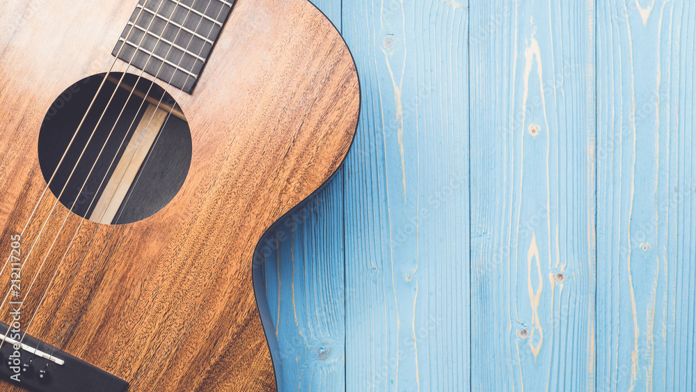 New brown guitar on wooden board - obrazy, fototapety, plakaty 