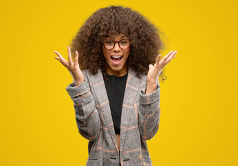 African american woman wearing a jacket very happy and excited, winner expression celebrating victory screaming with big smile and raised hands