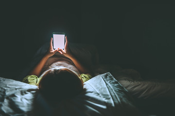 Asian woman play smartphone in the bed at night,Thailand people,Addict social media,Play internet all night