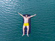 © phpetrunina14 - man on mattress in blue water. summer time concept